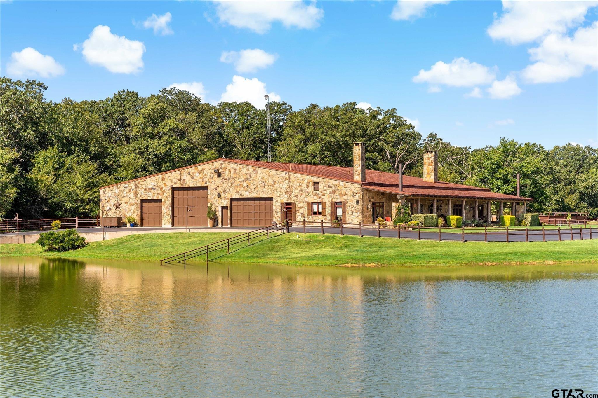 1450 County Road Sumner, TX 75486 - Photo 3 of 35 a view of a house next to a lake with a big yard