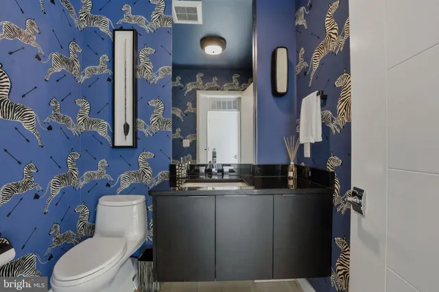 a large kitchen with a large counter top a sink stainless steel appliances and cabinets