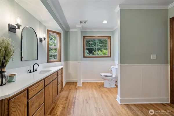 a bathroom with a double vanity sink a toilet and a window