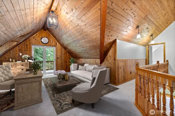 a living room with furniture a large window and wooden floor