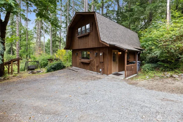 a view of a barn house with a large window and large tree