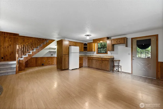 a view of an empty room with wooden floor and windows