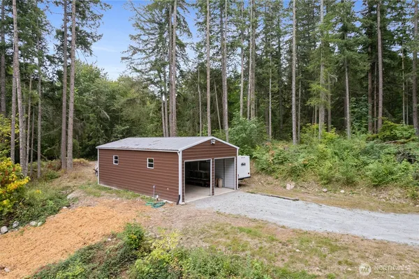 a front view of a house with a garden and trees