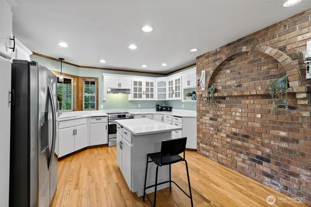 a kitchen with cabinets and wooden floor