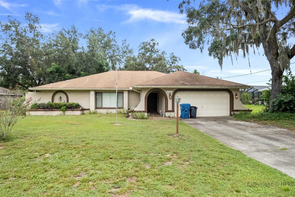 8345 Apple Orchard Road Spring Hill, FL 34608 - Photo 1 of 1 a front view of a house with a garden