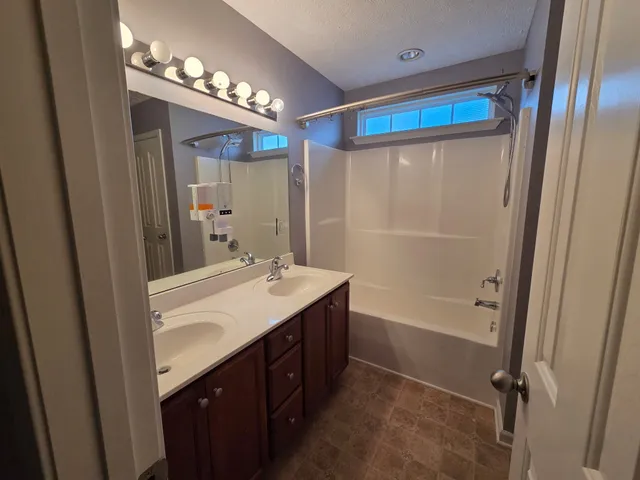 a bathroom with a sink a toilet a mirror and shower
