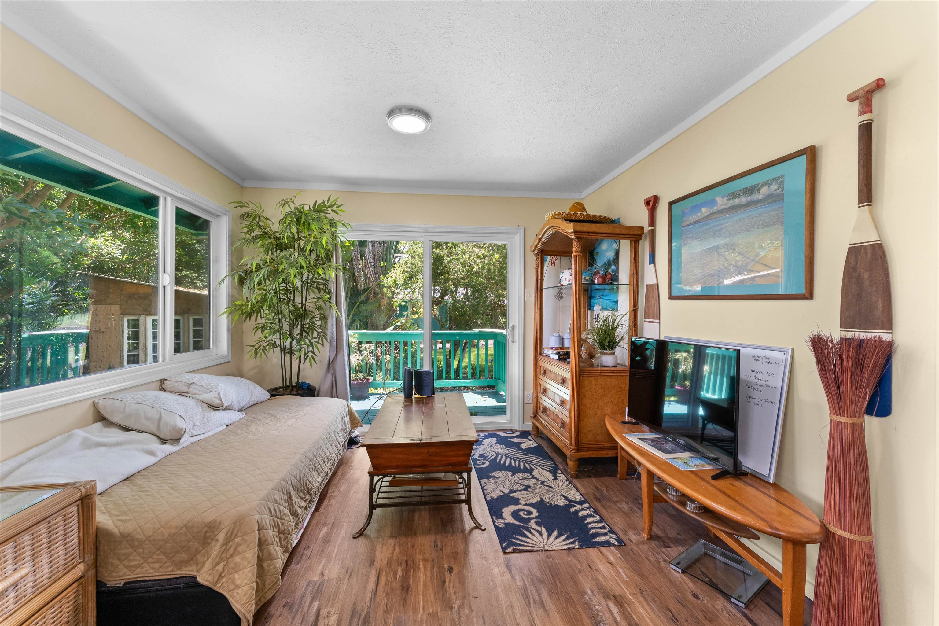 2115 Kaupakalua Road Haiku, HI 96708 - Photo 16 of 26 a living room with furniture a flat screen tv and a floor to ceiling window