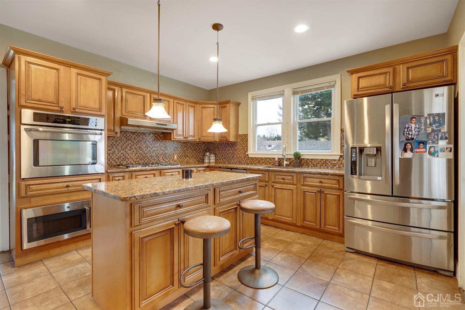 605 Beers Street Hazlet, NJ 07730 - Photo 11 of 32 a kitchen with stainless steel appliances granite countertop a refrigerator a stove a sink and white cabinets