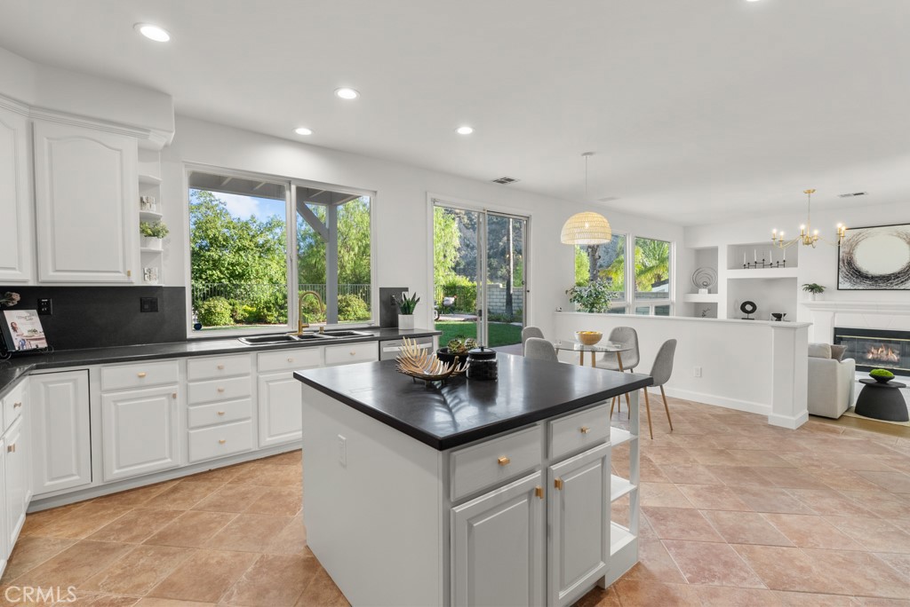 25930 Franklin Lane Stevenson Ranch, CA 91381 - Photo 8 of 47 a kitchen with kitchen island granite countertop a stove a sink a dining table and chairs