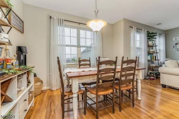 a dining room with furniture a chandelier and wooden floor