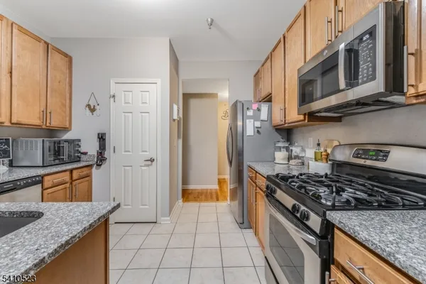 a kitchen with stainless steel appliances granite countertop a stove a sink and a refrigerator