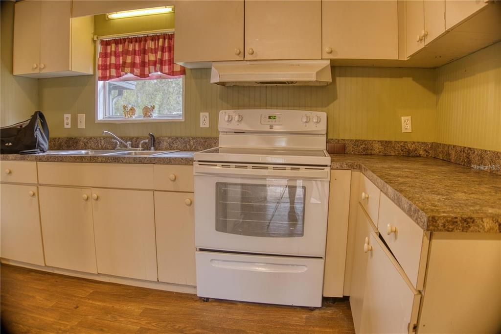 7230 James Stanaland Road Plant City, FL 33567 - Photo 11 of 26 a kitchen with granite countertop white cabinets and white appliances