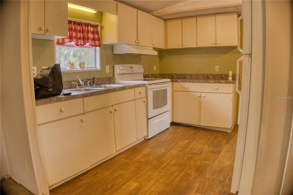 7230 James Stanaland Road Plant City, FL 33567 - Photo 10 of 26 a kitchen with white cabinets and white appliances