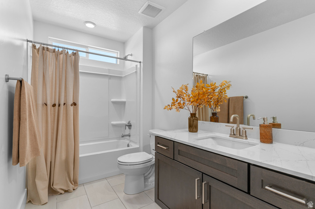 1418 West 2350th South, Unit 15 Perry, UT 84302 - Photo 16 of 22 Bathroom featuring a dark wood-finish vanity with a white countertop and integrated sink, a full-width mirror, a white toilet, and a white tub/shower combination with a transom window above