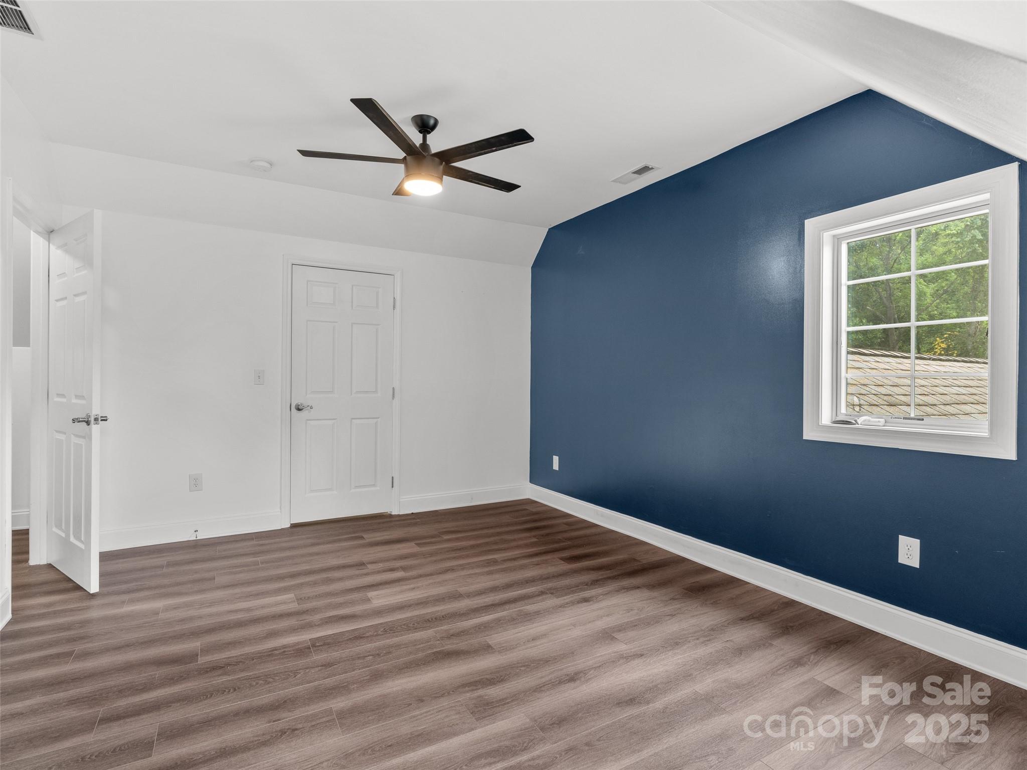 99 Curtis Parker Road Alexander, NC 28701 - Photo 15 of 24 a view of an empty room with wooden floor and a window