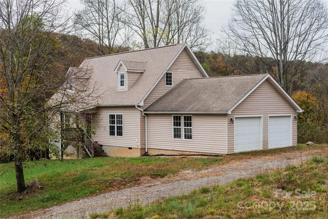 a view of a yard in front of a house with large trees