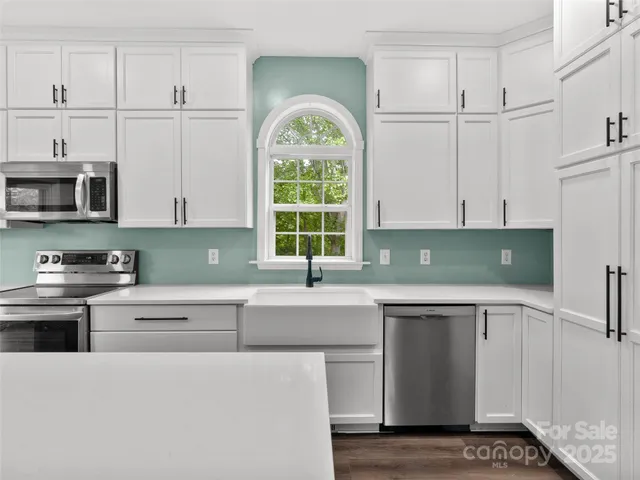 a kitchen with cabinets appliances and a sink
