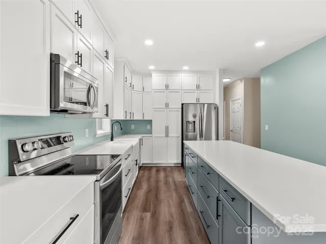a kitchen with white cabinets sink and stainless steel appliances