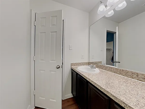 a bathroom with a granite countertop sink and a mirror