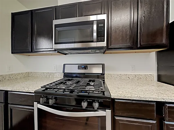 a kitchen with granite countertop stainless steel appliances and wooden cabinets