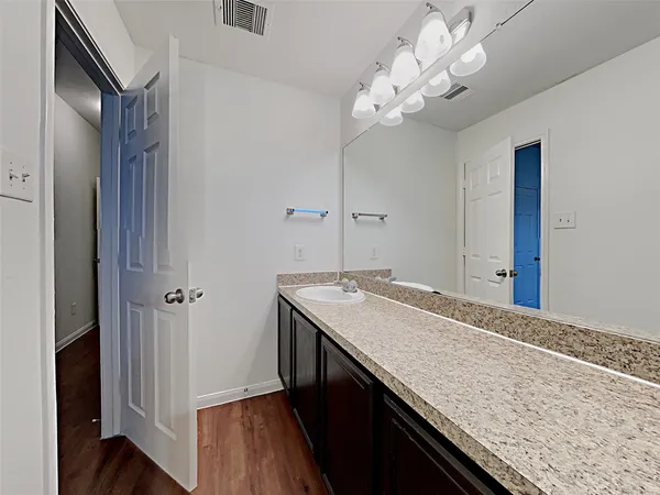 a bathroom with a granite countertop sink a large mirror and vanity