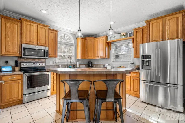 a kitchen with stainless steel appliances granite countertop a stove a sink refrigerator and a microwave
