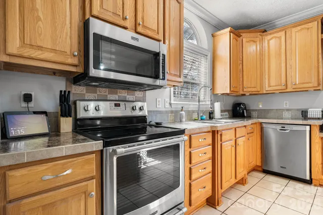 a kitchen with stainless steel appliances granite countertop a stove microwave and cabinets