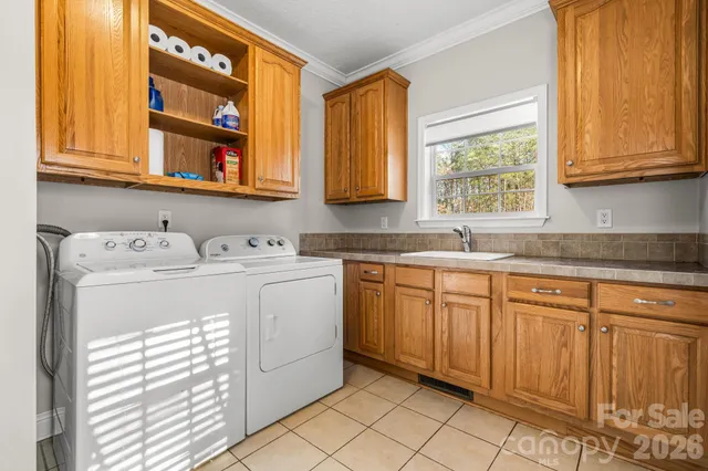 a utility room with cabinets washer and dryer