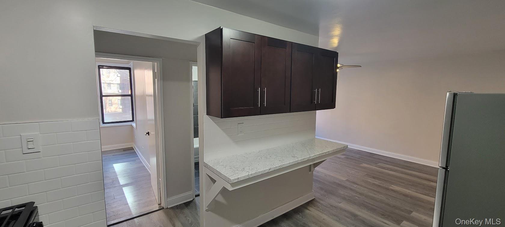 141-60 84th Road, Unit 2G Queens, NY 11435 - Photo 5 of 11 a view of an empty room with wooden floor and cabinet