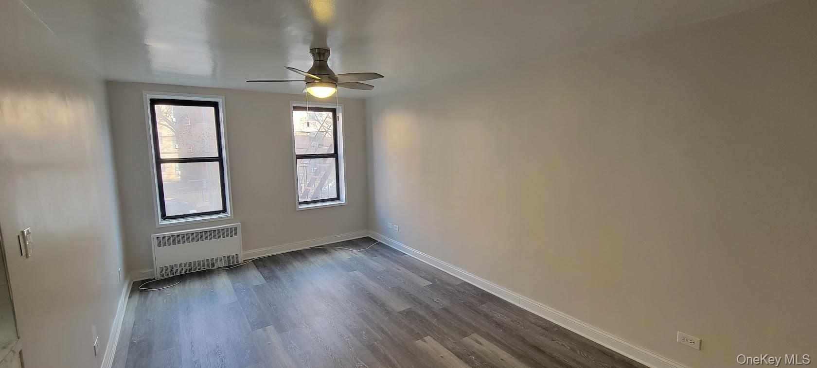 141-60 84th Road, Unit 2G Queens, NY 11435 - Photo 7 of 11 wooden floor in an empty room with a window