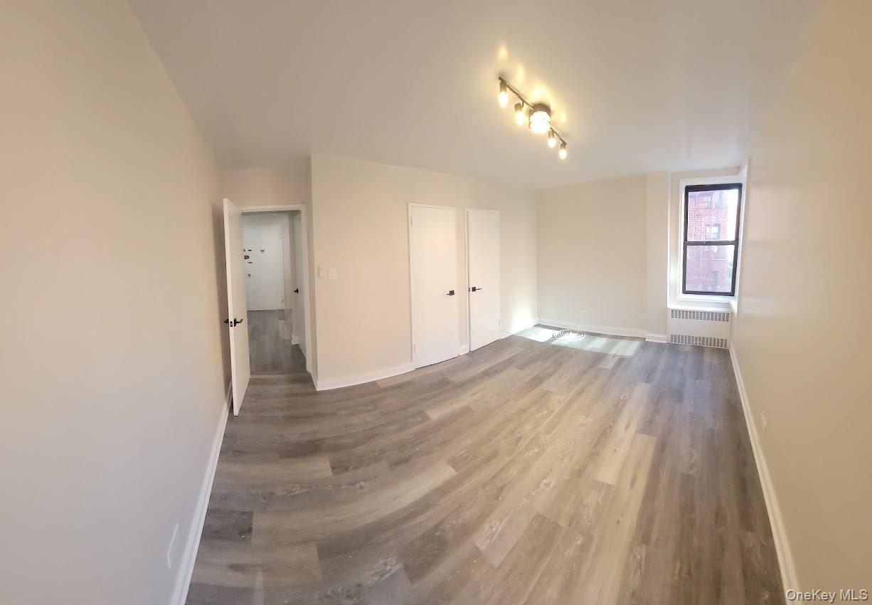 141-60 84th Road, Unit 2G Queens, NY 11435 - Photo 9 of 11 a view of a room with wooden floor and a window