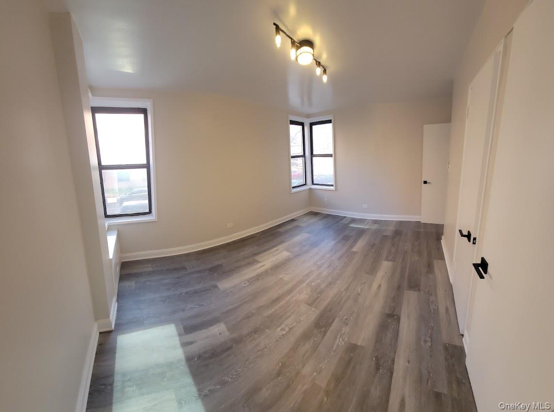 141-60 84th Road, Unit 2G Queens, NY 11435 - Photo 10 of 11 wooden floor in an empty room with a window