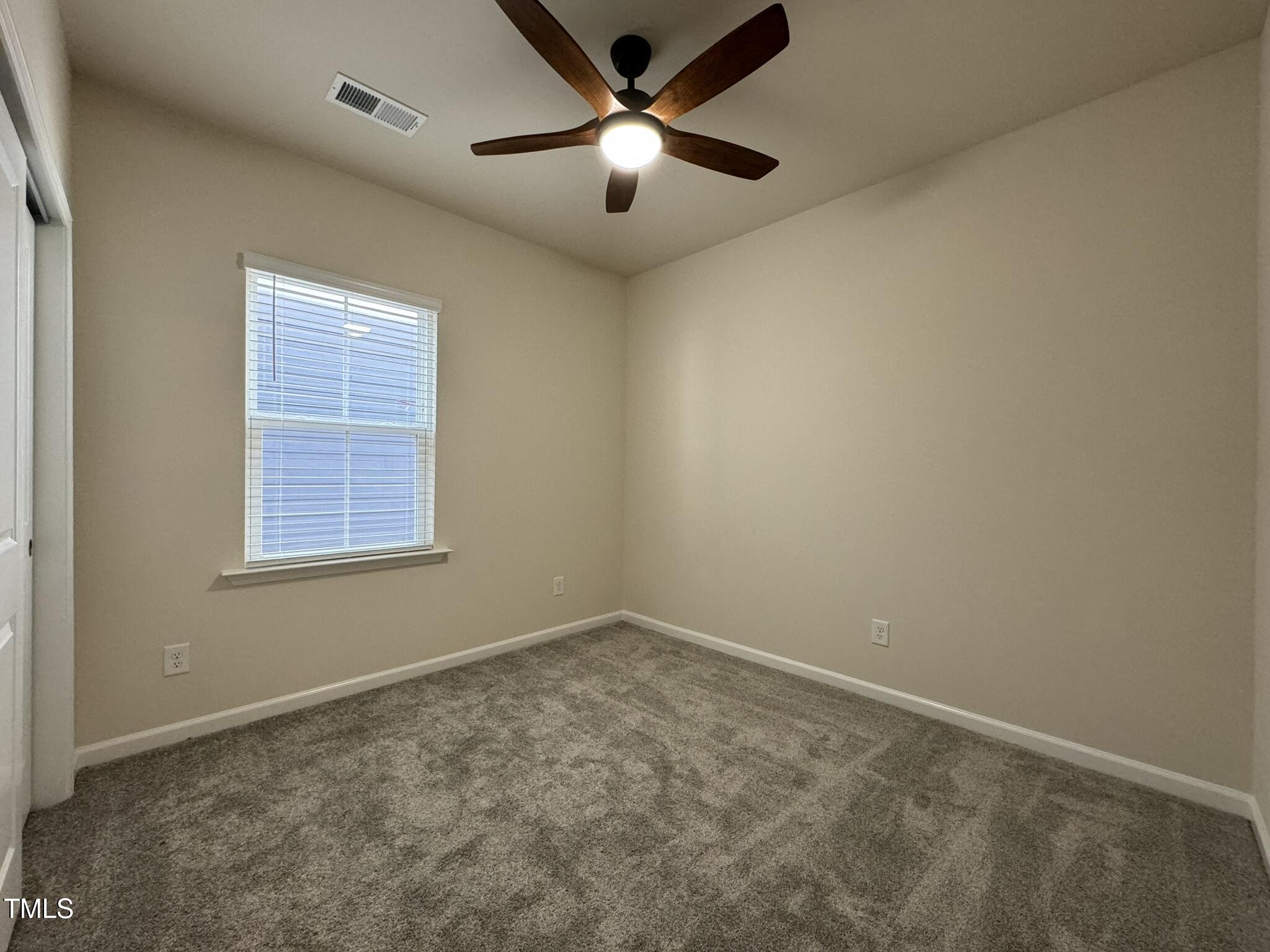 128 Katrine Way Raleigh, NC 27603 - Photo 12 of 34 an empty room with a window and a ceiling fan