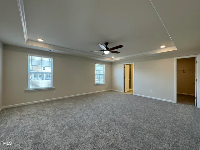 an empty room with windows and ceiling fan