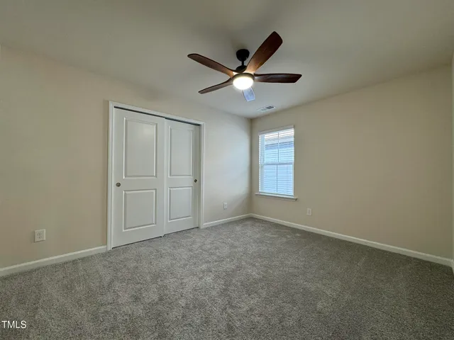 an empty room with closet and windows