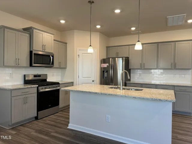 a kitchen with stainless steel appliances wooden cabinets a sink and a stove