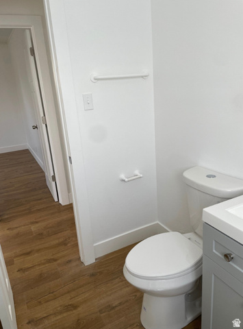 230 North 2nd Street Tooele, UT 84074 - Photo 9 of 18 Bathroom featuring wood-finish flooring, a white toilet, a grey vanity with a white countertop, and white baseboards