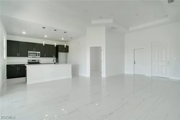 a view of kitchen with stainless steel appliances a refrigerator and a stove top oven