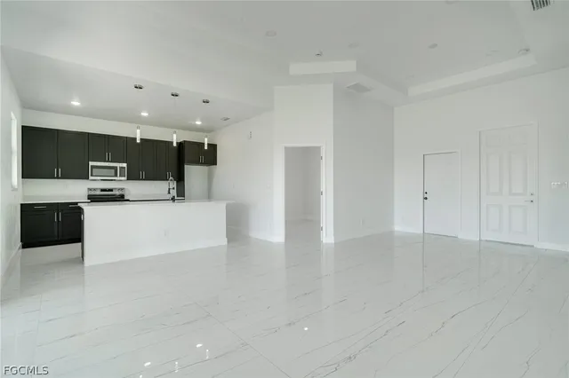 a view of kitchen with stainless steel appliances a refrigerator and a stove top oven