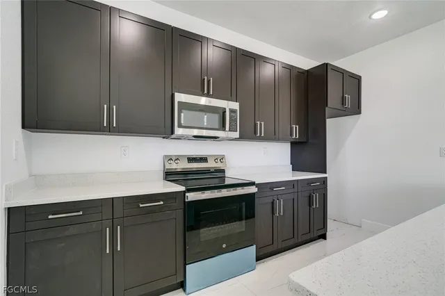 a kitchen with stainless steel appliances granite countertop a stove a refrigerator and a microwave