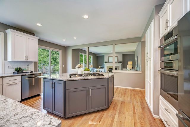 a kitchen with granite countertop stainless steel appliances and wooden cabinets