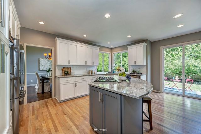 a kitchen with a sink appliances cabinets and wooden floor