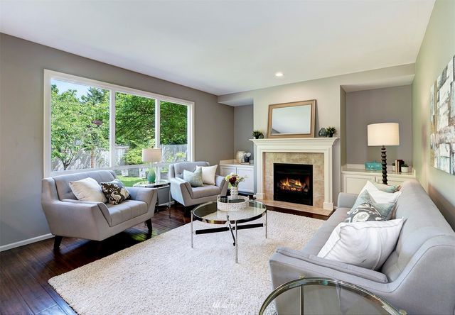 a living room with furniture a large window and a fireplace