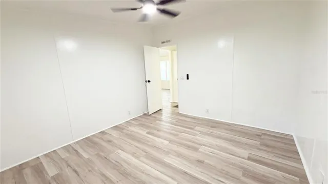 a view of empty room with wooden floor