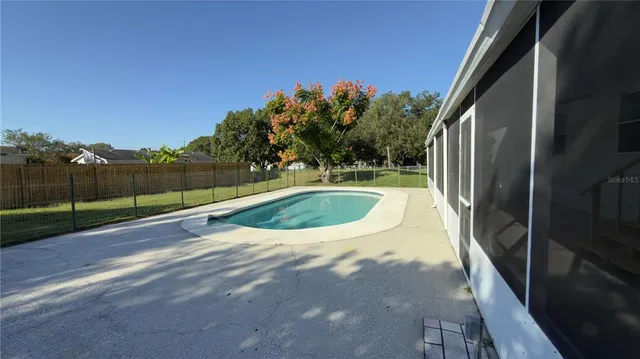 a view of a swimming pool with a yard and sitting area