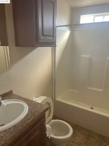 a bathroom with a granite countertop sink toilet and bathtub