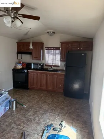 a kitchen with granite countertop a sink cabinets and stainless steel appliances