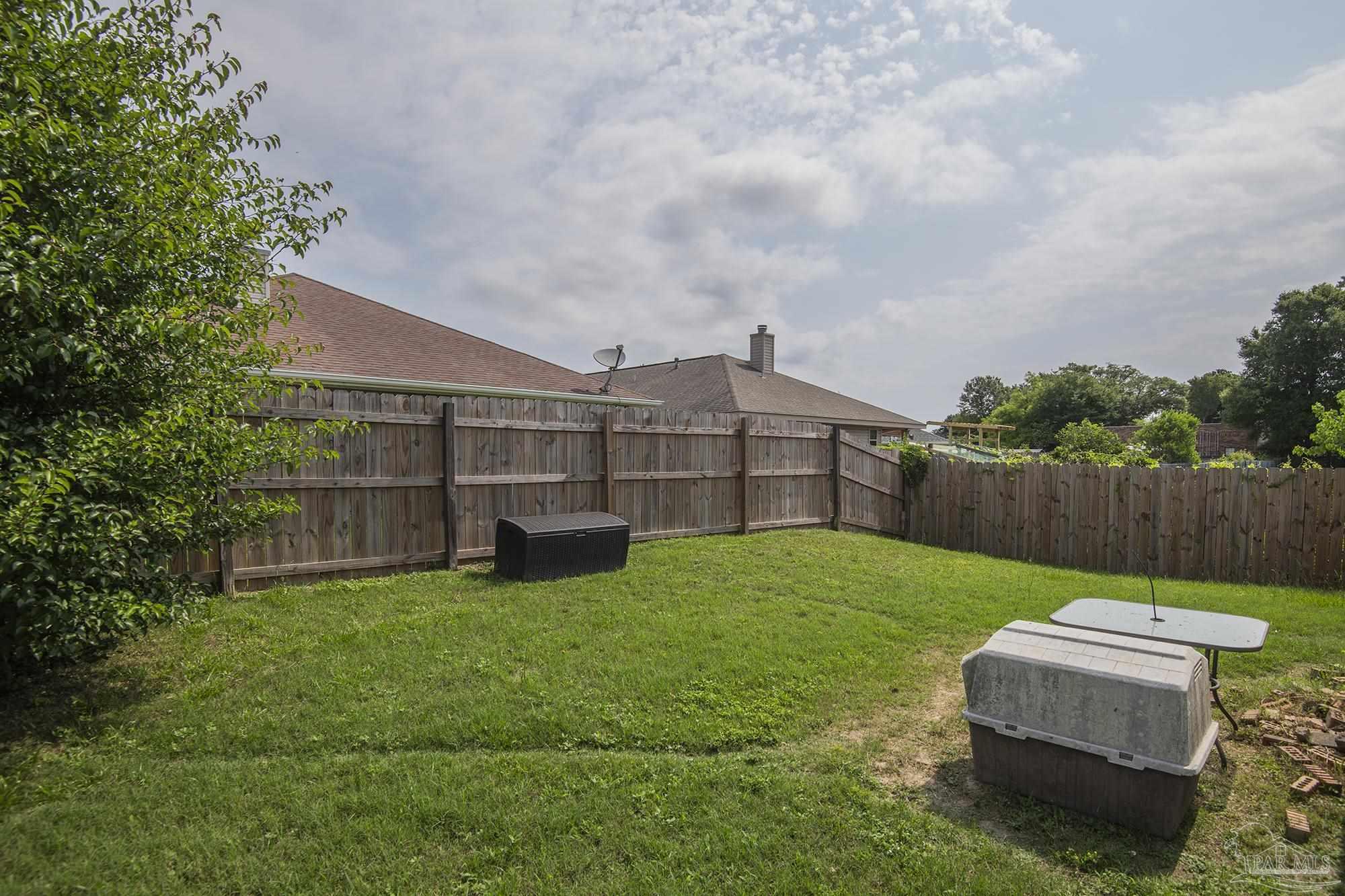 5800 Providence Loop Pensacola, FL 32526 - Photo 27 of 29 a view of a backyard with couches plants and wooden fence