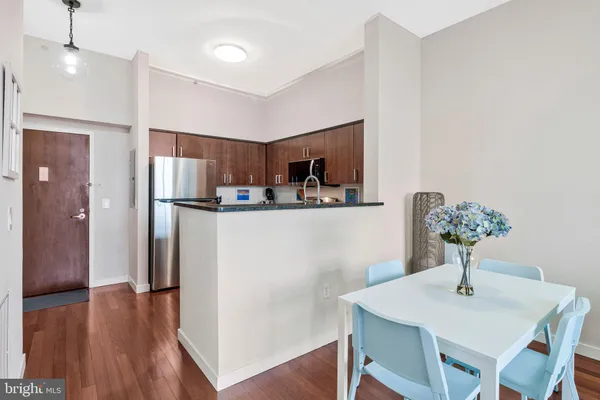 a kitchen with stainless steel appliances granite countertop a refrigerator a stove a sink dishwasher and microwave with wooden floor