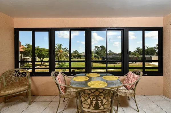 a dining room with furniture and large windows